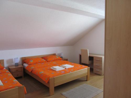 a bedroom with an orange bed and a desk at Natasa Apartments in Jezerce