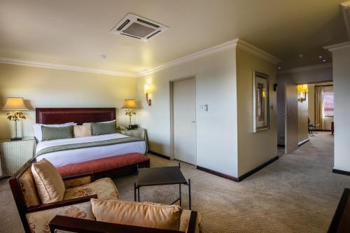 a hotel room with a bed and a couch at Cresta President Hotel in Gaborone