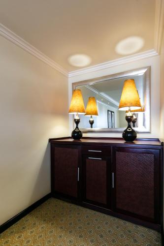 a room with a vanity with two lamps and a mirror at Cresta President Hotel in Gaborone