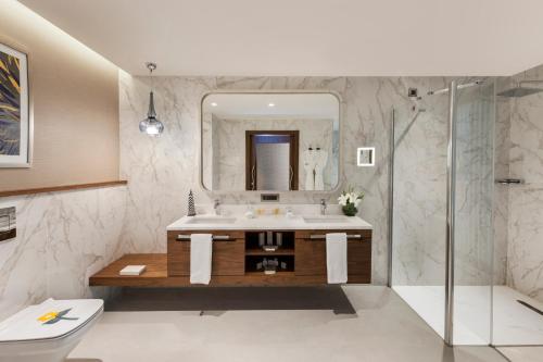 a bathroom with a sink and a mirror at Elite World Grand Istanbul Küçükyalı in Istanbul