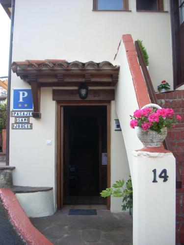 a door to a building with a pot of flowers at Pasaje San Jorge in Comillas