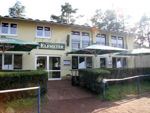 a building with two umbrellas in front of it at Pension Elfmeter in Rheinsberg