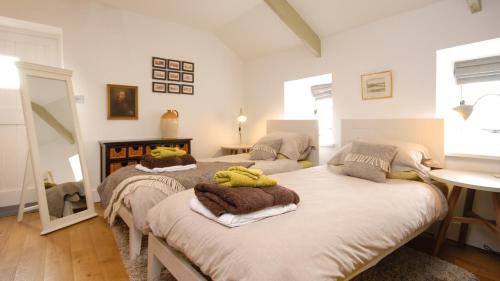 a bedroom with two beds with towels on them at Saddle and Stable Rooms in Sennen