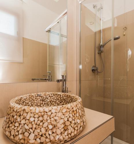 a bathroom with a shower with a large stone tub at Albergo Della Corte in Benevento