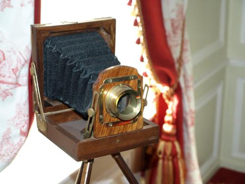 an old camera on a tripod in front of a mirror at Châtellerie De Schoebeque in Cassel