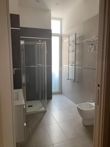 a bathroom with a shower and a toilet and a sink at Hotel Ausonia in Naples
