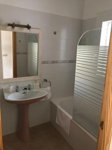 a bathroom with a sink and a mirror and a tub at Casa S Estany in La Savina