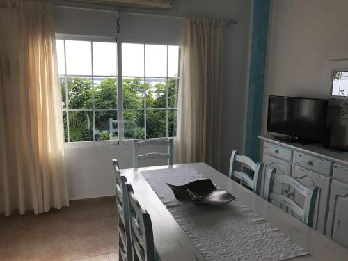 a dining room with a table and a large window at Casa S Estany in La Savina