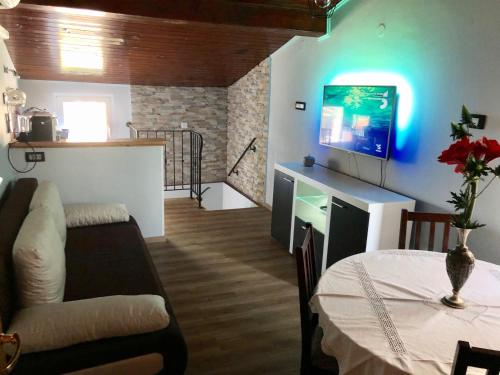 a living room with a couch and a tv and a table at Apartment Boreas in Strunjan