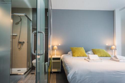 a bedroom with a bed and a glass shower at YEY Baleal in Peniche