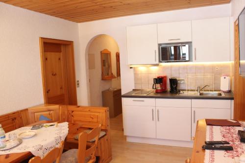 a kitchen with a table and chairs and a refrigerator at Landgasthof zum Schützen in Oberried