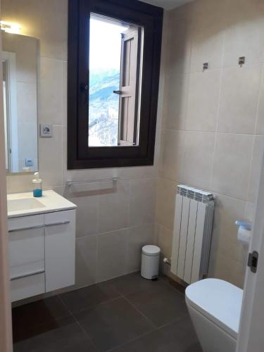 a bathroom with a toilet sink and a window at Pleta del Mon Atico in Benasque