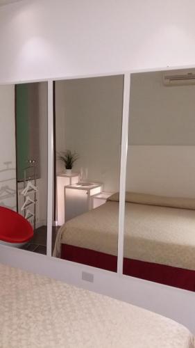 a bedroom with a bed and a red chair at Albergo Della Corte in Benevento