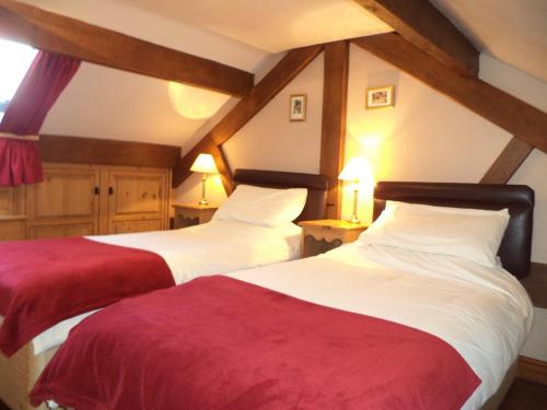 two beds sitting in a room with two lamps at Moorhen Cottage in Stoke on Trent