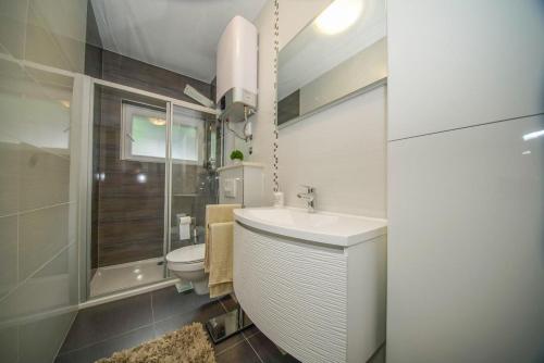 łazienka z białą umywalką i toaletą w obiekcie Apartman Mate w mieście Splitska