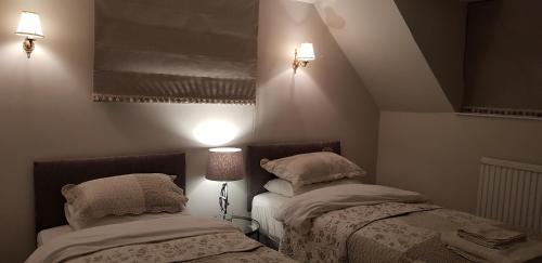 duas camas num pequeno quarto com duas lâmpadas em Newton Park Farm em Turvey