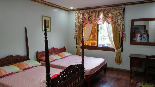 a bedroom with two beds and a window at Casa Familya in Batac