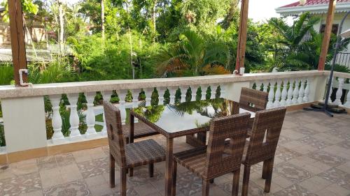 a patio with two chairs and a table on a balcony at Casa Familya in Batac