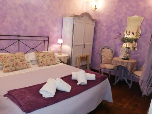um quarto com paredes roxas e uma cama com duas almofadas em La Serra Sul Mare em Monterosso al Mare