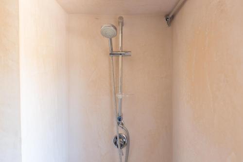 a shower with a shower head on a wall at Masseria Castelluzzo in Ceglie Messapica