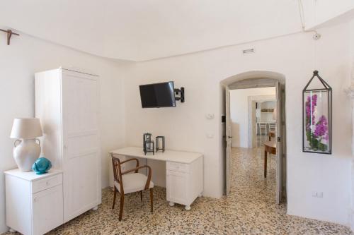 a white room with a desk and a tv on the wall at Masseria Castelluzzo in Ceglie Messapica
