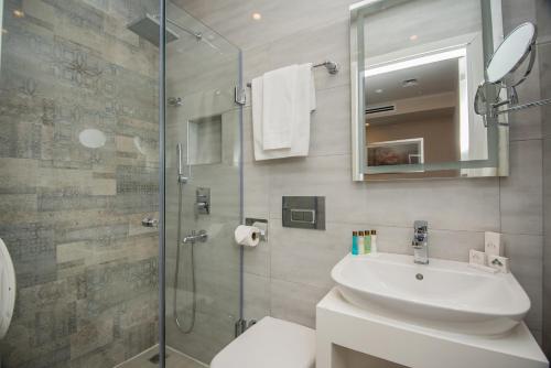 a bathroom with a sink and a glass shower at City Avenue Hotel in Tbilisi City
