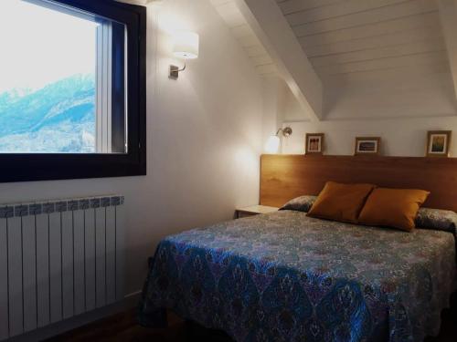 a bedroom with a bed and a large window at Pleta del Mon Atico in Benasque