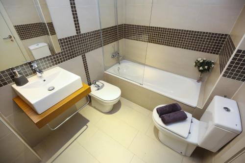 a bathroom with a sink and a toilet and a tub at Tropicana Planet Costa Dorada in Cambrils