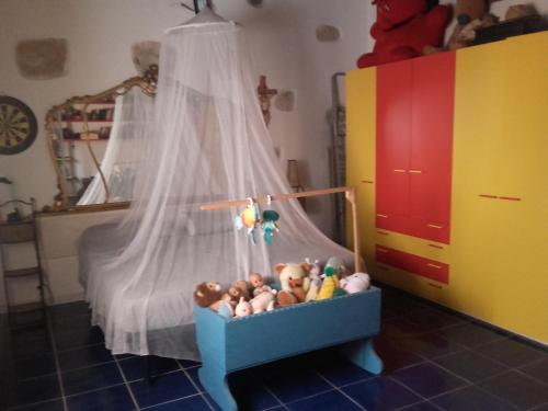 a crib filled with stuffed animals in a bedroom at Appartamento in Carloforte