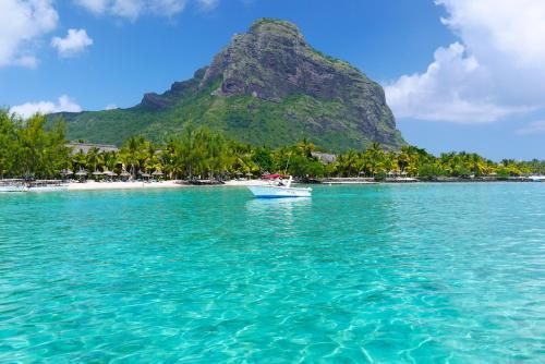 a boat in the water in front of a mountain at Résidence An&Sy - Loft à Surinam in Surinam