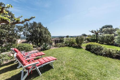 een rij rode stoelen op een gazon bij Esprit du Sud Damien in Roquebrune-sur-Argens