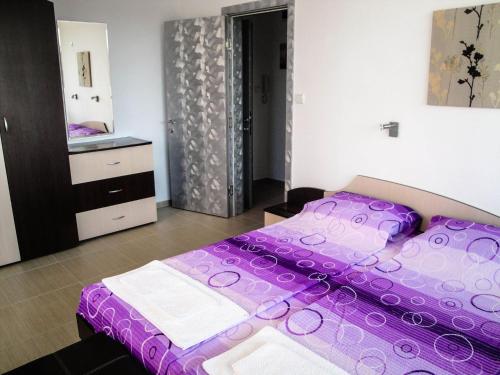 アフトポルにあるAhtopol Pearl Apartmentsのベッドルーム(紫色のベッド1台付)、バスルーム