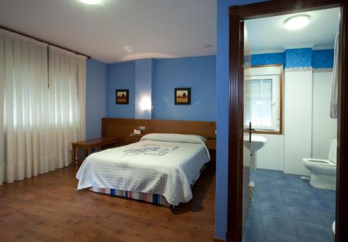 a bedroom with a bed and a bathroom with a toilet at HOTEL PARRILLADA TERRANOVA in Oza dos Ríos