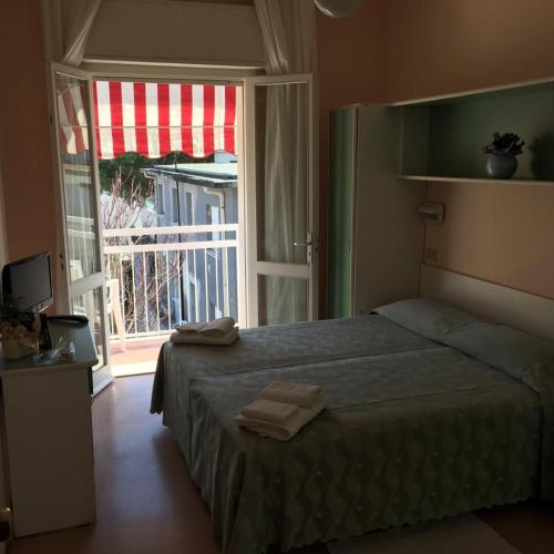 a bedroom with a bed and a large window at Hotel Ville De Paris in Riccione