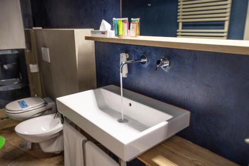 a bathroom with a white sink and a toilet at Ambienthotel PrimaLuna 3S in Malcesine
