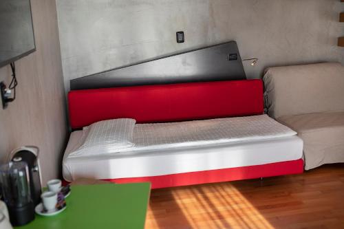 a red and white bed in a room at Ambienthotel PrimaLuna 3S in Malcesine