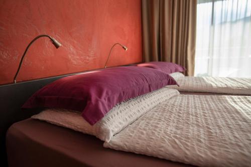 a bedroom with two beds with purple and white pillows at Ambienthotel PrimaLuna 3S in Malcesine
