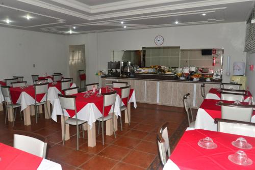 a restaurant with red and white tables and a kitchen at HOTEL D' LUCCA in Ubá