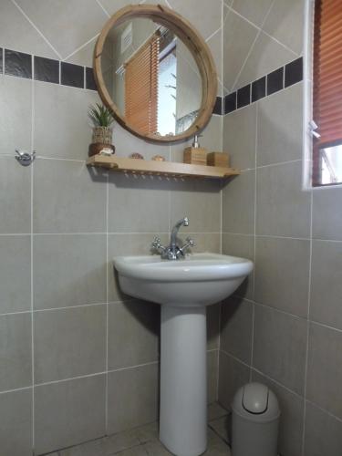 a bathroom with a sink and a mirror at HAPPY PLACE @ 3 in St Lucia