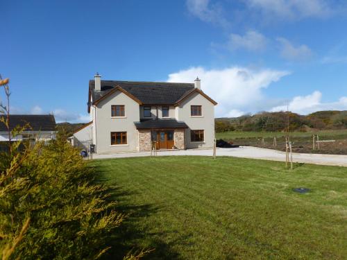 a large white house with a large yard at Crag Na Cor B&B in Culdaff