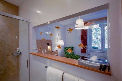 ein Bad mit einem Waschbecken und einem Spiegel in der Unterkunft Strandhotel Alte Donau in Wien