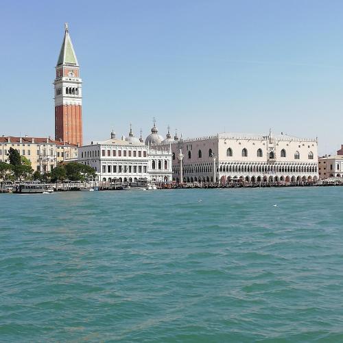 a large building with a clock tower next to the water at Hotel Maison Ducal in Venice
