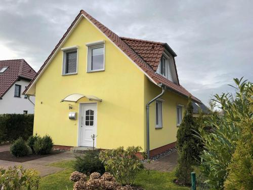 een geel huis met een rood dak bij Ferienhaus Uns lütt Hus mit Sauna in Baabe