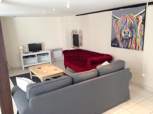 a living room with a red couch and a table at Eymet Townhouse in Eymet