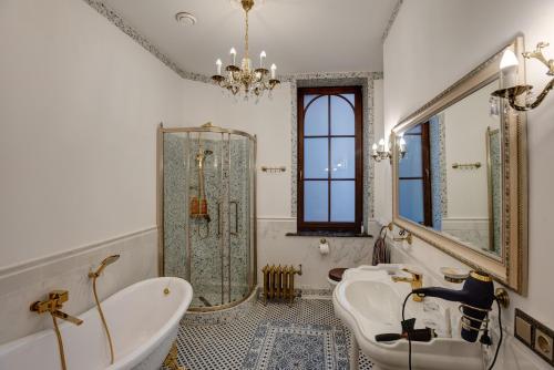 een badkamer met twee wastafels, een bad en een douche bij Dandelion Apartment Vecpilsētas in Rīga