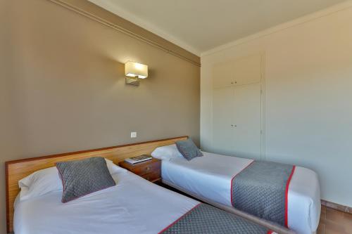 a hotel room with two beds and a lamp at Hostal Alberana in Verges