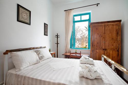 een slaapkamer met een bed met witte lakens en een raam bij Bougainvillea Garden in Lefkosa Turk