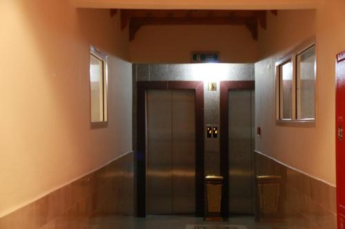 a hallway with two elevators in a building at Horizon Hotel Apartments - الأفق للشقق الفندقية in Al Khawḑ