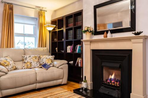 a living room with a couch and a fireplace at Salmons Leap Sneem Village Kerry in Sneem