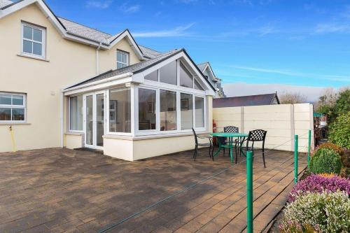 a house with a patio with a table and chairs at Salmons Leap Sneem Village Kerry in Sneem